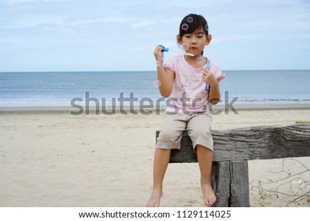 Portrait Asian Thailand kids cute little girl Blow bubbles Happy smile background sea