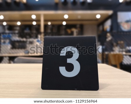 Waiting number for food on the table, close​ up, blurred​