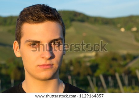 Young handsome man with brown eyes looking at the camera at sunset