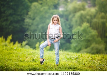 portrait of little beautiful stylish kid girl on green forest background