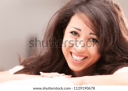 young woman cheering to you on her sofa in her living room