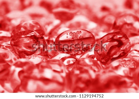 Red plastic beads with air bubbles inside create an abstract picture. Close up, shallow depth of field. Focus on сentral beads. Stylish background.
