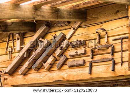 Old rusty tools for carpenter at the wood wall of the house. Plane hand, jointer hand, drill hand and others.