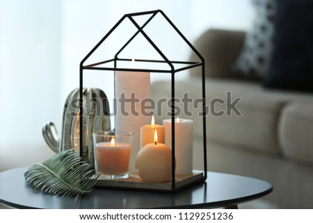 Burning candles on table against blurred background