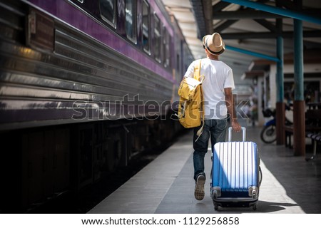 Traveler walking and waits train at train station for travel in summer. Travel concept. Royalty-Free Stock Photo #1129256858