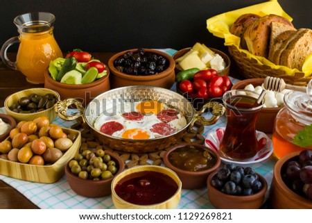 Fresh Traditional Turkish Village Breakfast on the wooden table with copper egg pan,ceramic casserole and bamboo breakfast set.