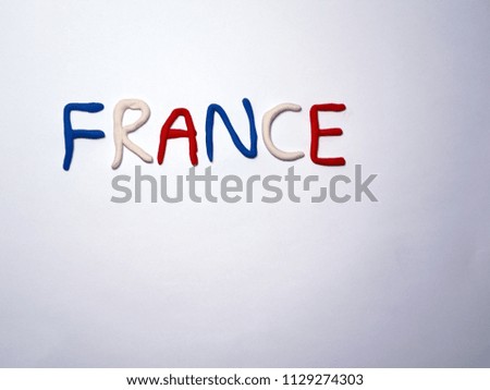 alphabet FRANCE made with colorful(blue, white and red) clays and background is white.