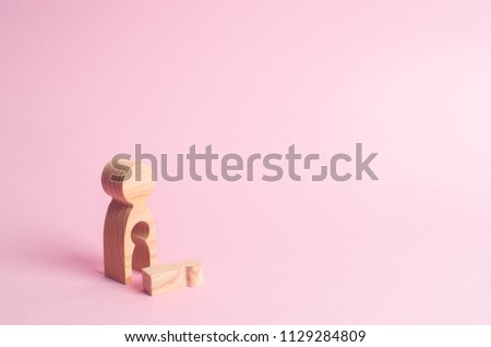 A wooden figure of a woman with a void from which a child fell. The concept of the loss of a child, abortion of pregnancy, miscarriage. mother lost her child. Deprivation of parental rights. Royalty-Free Stock Photo #1129284809