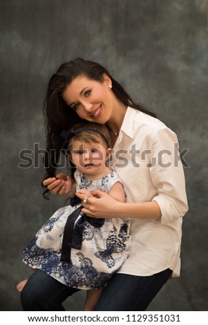 Little daughter sits on her mother's lap