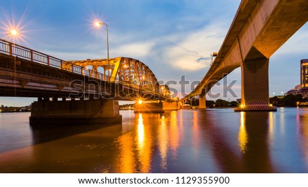 Metal bridge crossing river night view with reflection light