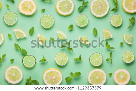 Slices of fresh lemon and lime pattern on pastel green 
background in minimalist style. Flat lay, copy space. Royalty-Free Stock Photo #1129357379