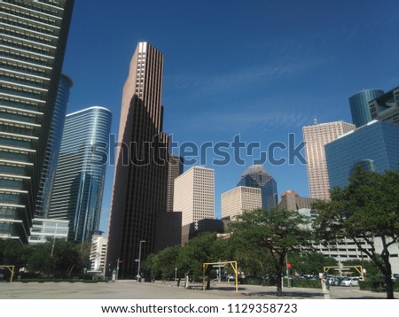 A walk through the beautiful streets of Houston, Texas, United States of America. In the image skyscrapers and an intense blue sky define the skyline of the city with open space areas for recreation. 
