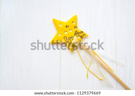 fairy magic star stick with gold paillettes, ribbons, rose on white wooden background