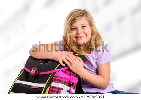 blond girl with schoolbag on first day at school