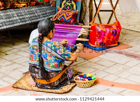 Woman weaving in an old village in Guatemala.

 Traditional waver from Guatemala. Royalty-Free Stock Photo #1129421444