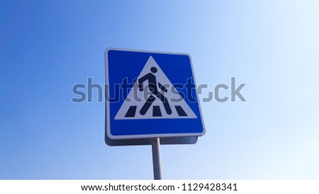 Pedestrian sign on a blue