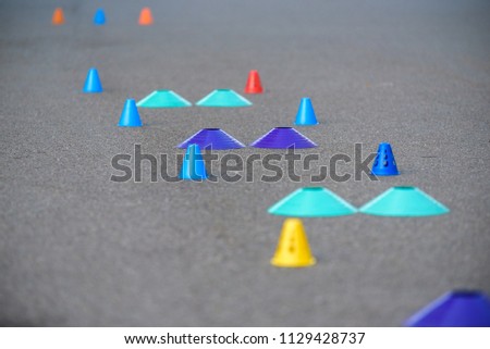 Cones for slalom on roller skates stand on asphalt, inline.