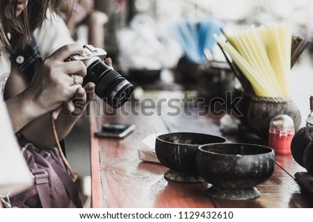 Young woman prepares a camera ready to take a photo at riverside of Amphawa, Thailand