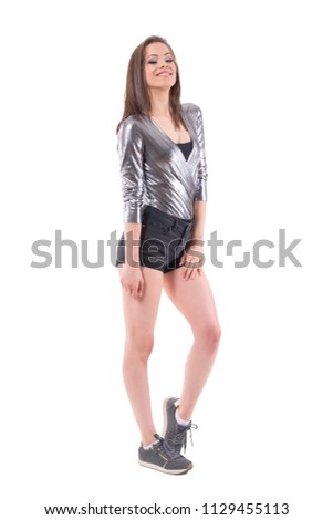 Beautiful teenage young stylish woman posing and smiling at camera in silver shiny shirt. Full body isolated on white background.