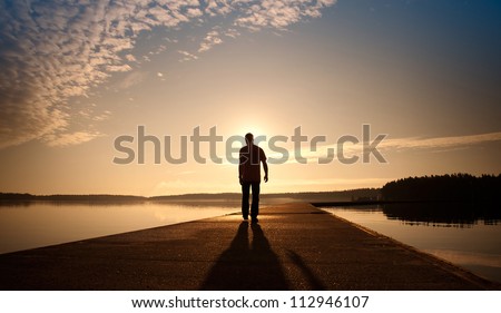 A man goes on the concrete pier in the sunrise