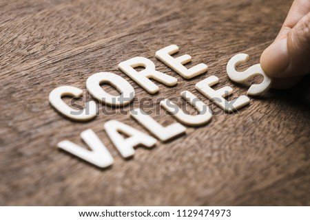 Closeup hand arrange wood letters as CORE VALUES word Royalty-Free Stock Photo #1129474973