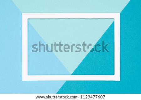 Abstract geometrical flat lay pastel blue and turquoise colored paper background. Minimalism, geometry and symmetry template with empty picture frame mock up.