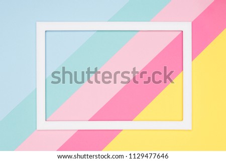 Abstract geometrical pastel blue, pink and yellow paper flat lay background. Minimalism, geometry and symmetry template with empty picture frame mock up.