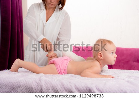 the doctor conducts a massage procedure on the table in the room of the house, massage at home. The concept of health, motherhood