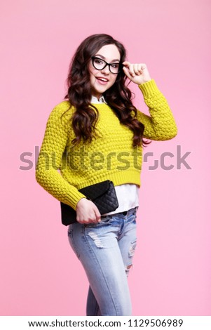 Young woman with black handbag on pink background