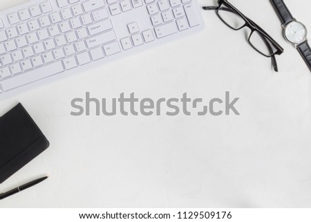 Flat lay office desk with computer keyboard and notepad on light background