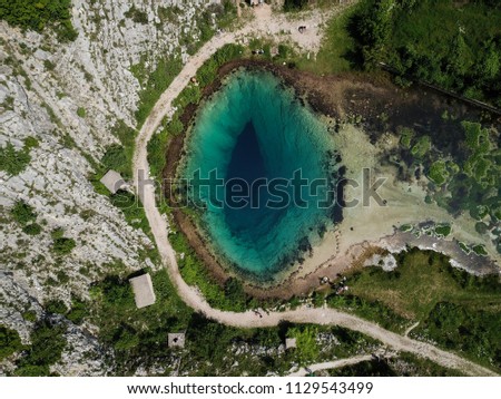 The spring of the Cetina River (izvor Cetine) in the foothills of the Dinara Mountain is named Blue Eye (Modro oko). Cristal clear waters emerge on the surface from a more than 100 meter-deep shaft. Royalty-Free Stock Photo #1129543499