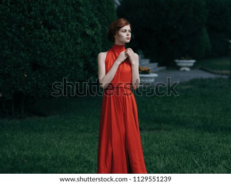 woman standing in the park, red long dress
