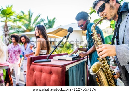 Multiethnic group of friends making party in a lounge bar - Cheerful young adults having fun and celebrating outdoors