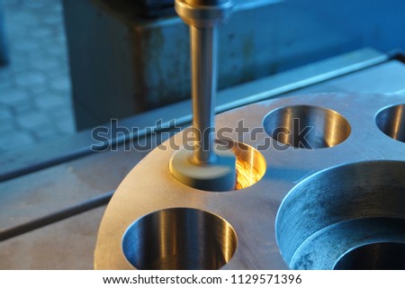 Processing of metal on a grinding machine with sparks, at an industrial plant.