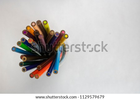 A jar of colored pencils on an isolated white background with room for text viewed from above 