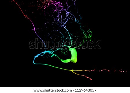 Colored paint splashes isolated on black background.