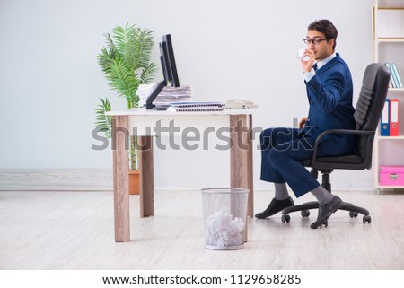 Young handsome businessman employee working in office in paperwo