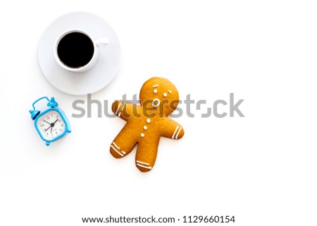 Time for coffee break. Coffee cup near gingerbread man, alarm clock on white background top view copy space