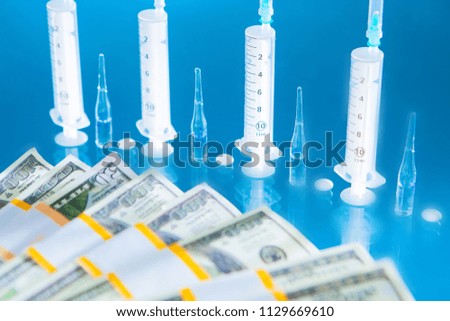 Syringes and ampoules. Medical concept on a blue background. Syringes on a glass table.