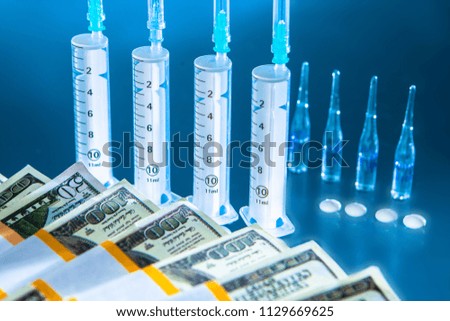 Syringes and ampoules. Medical concept on a blue background. Syringes on a glass table.