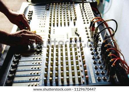 Hand of the sound engineer on the mixer.