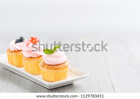 3 of cupcakes arrange on long white plate on table with blur background, dessert bakery in minimal concept.