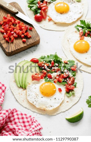 Mexican tortilla with salsa, avocado and egg on concrete background, selective focus. Tasty tacos