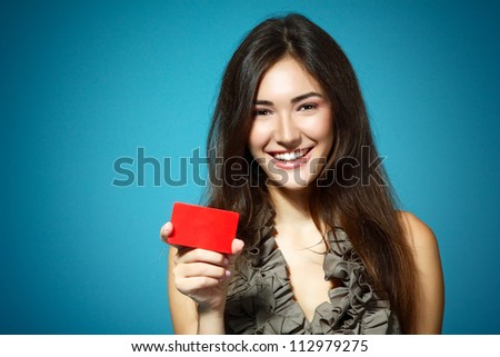 beautiful friendly smiling confident girl showing red card in hand, over blue background