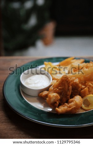 Fish and chips fried fish and potatoes on wood background vintage style