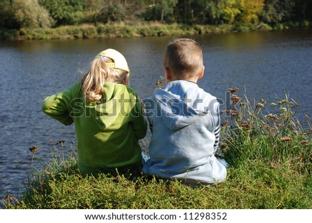 Girl and boy fishing on the river