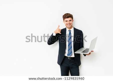 elegant businessman or salesman, standing on white background with laptop, showing phone call sign