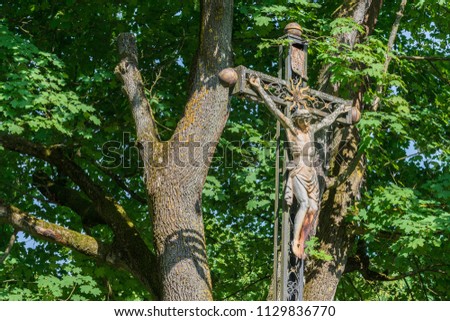 Weathered iron cross with Jesus statue