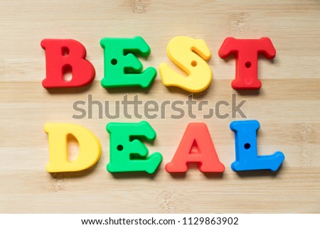 Color plastic alphabet in word best deal on wood background