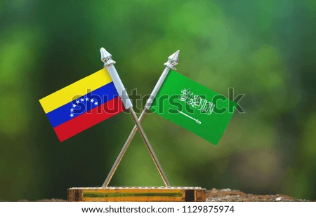 Saudi Arabia and Venezuela small flag with blur green background